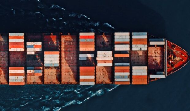 Aerial view of a large container ship navigating through blue waters