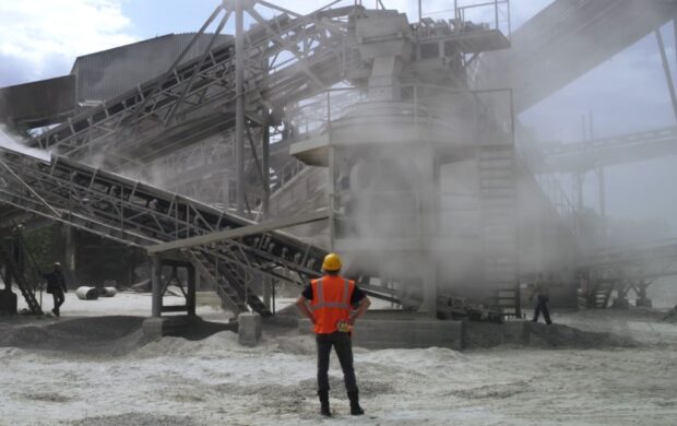 Industrial machinery in operation, with a worker observing the process
