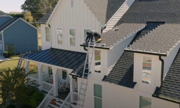 Professional repairing roof and gutters on a house